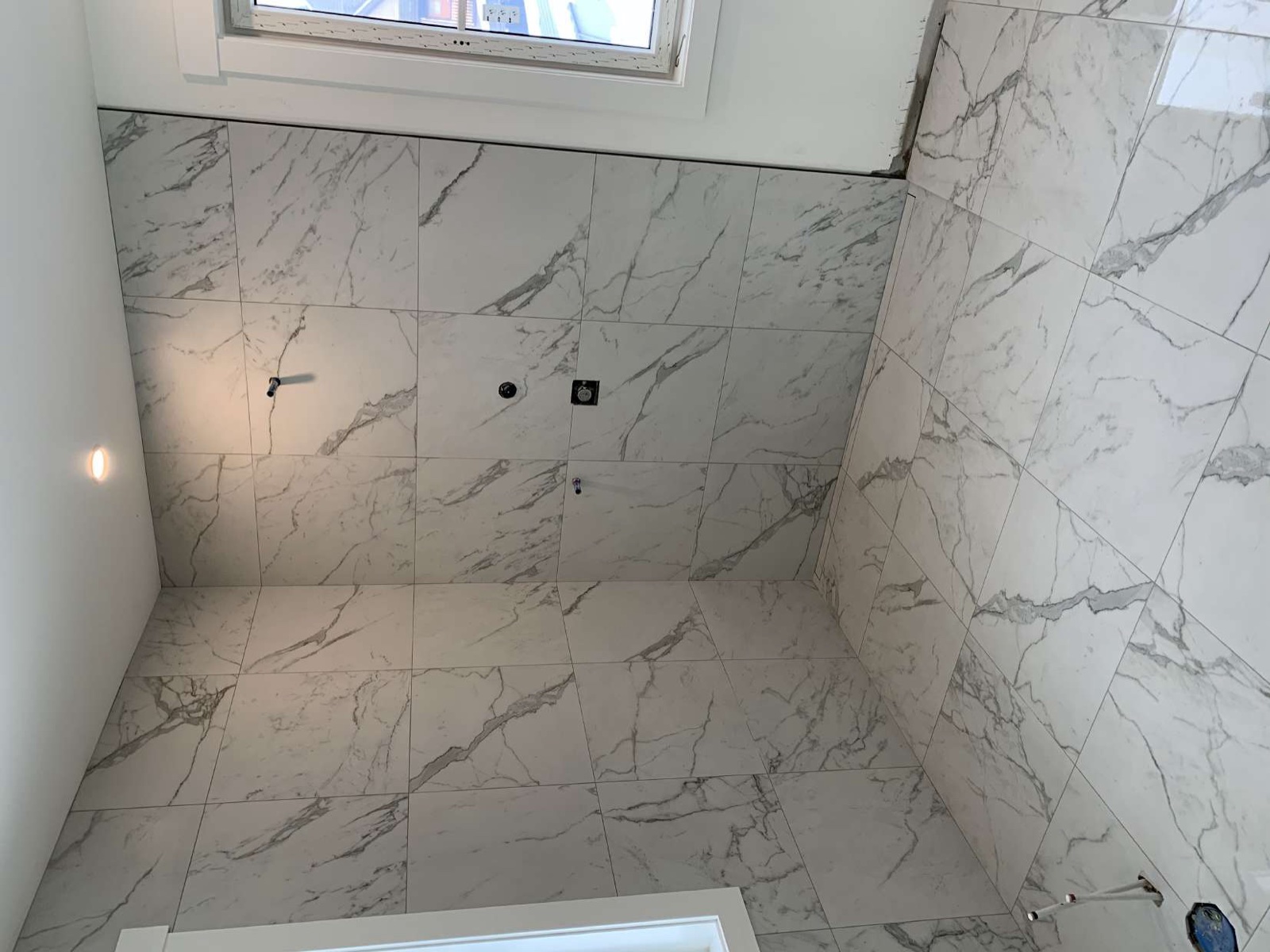 Book-matched marble tile walls with precision veining