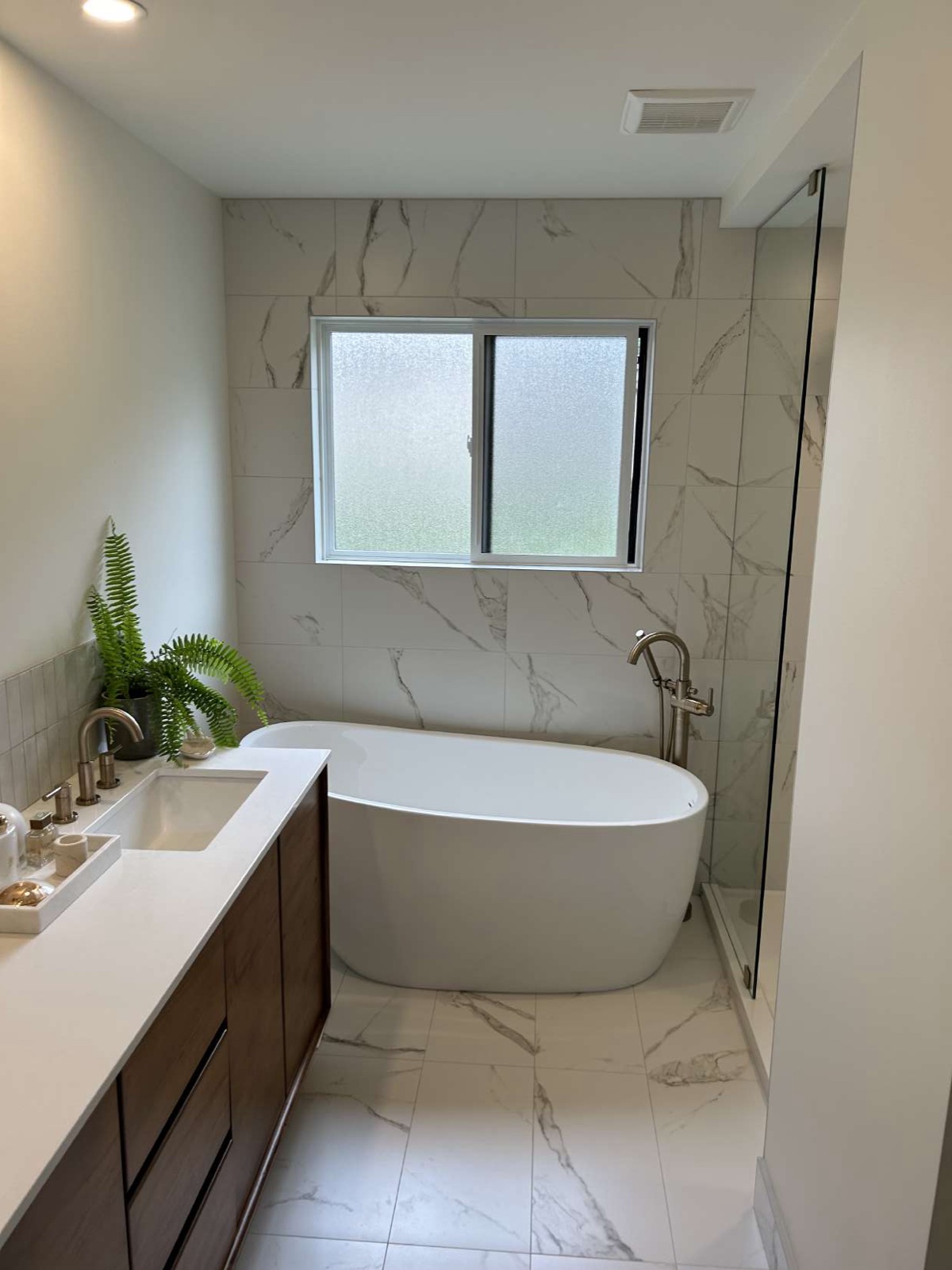 Bright marble ensuite bathroom with framed window