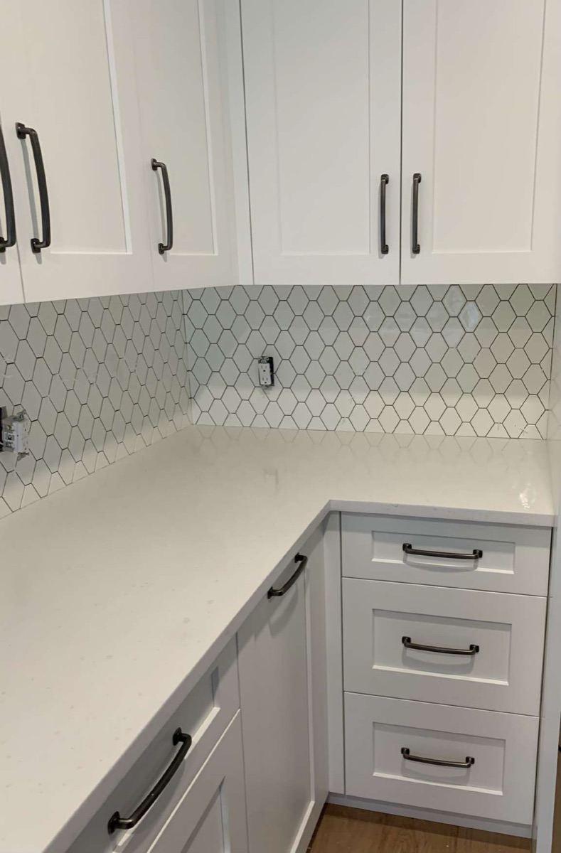 Arabesque mosaic backsplash with quartz counter and matte-black hardware