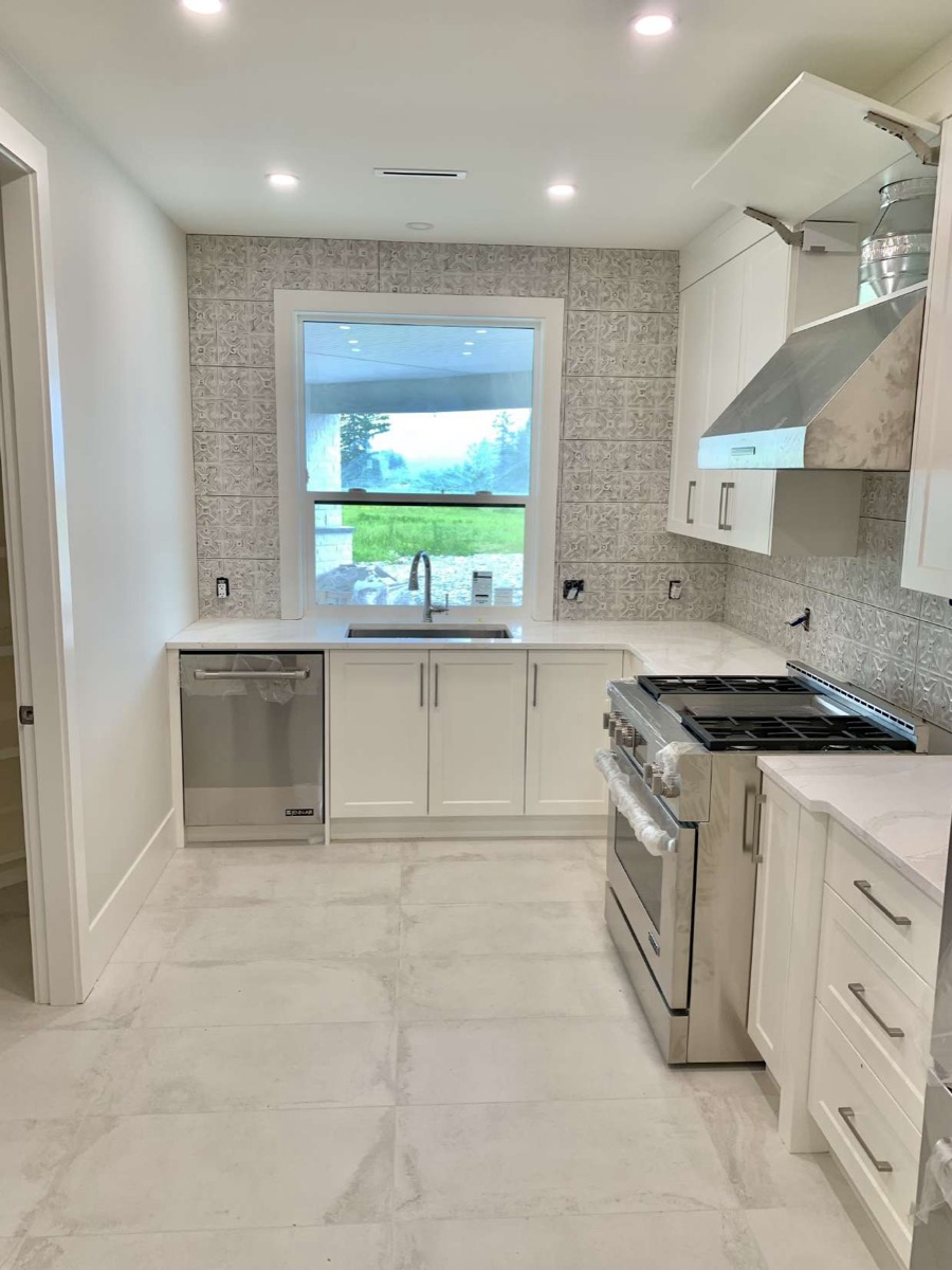 Bright kitchen with large-format marble-look floor tile and textured backsplash